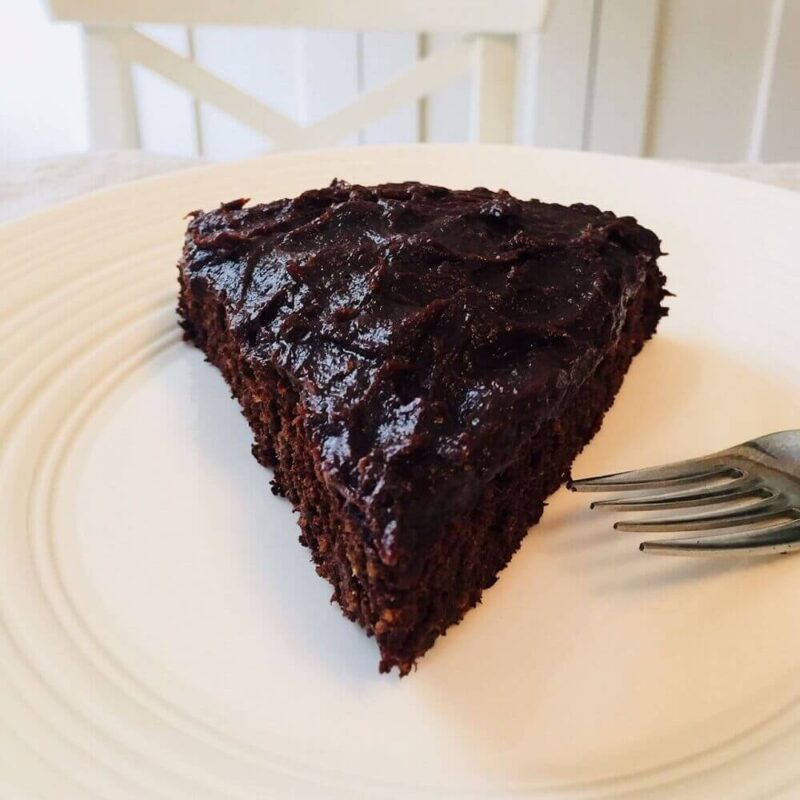 Slice of chocolate cake on a plate with a fork.