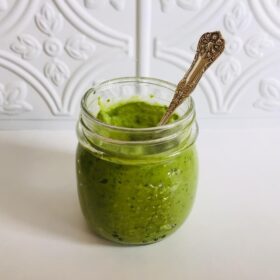 A jar of vegan green goddess dressing on a white counter.