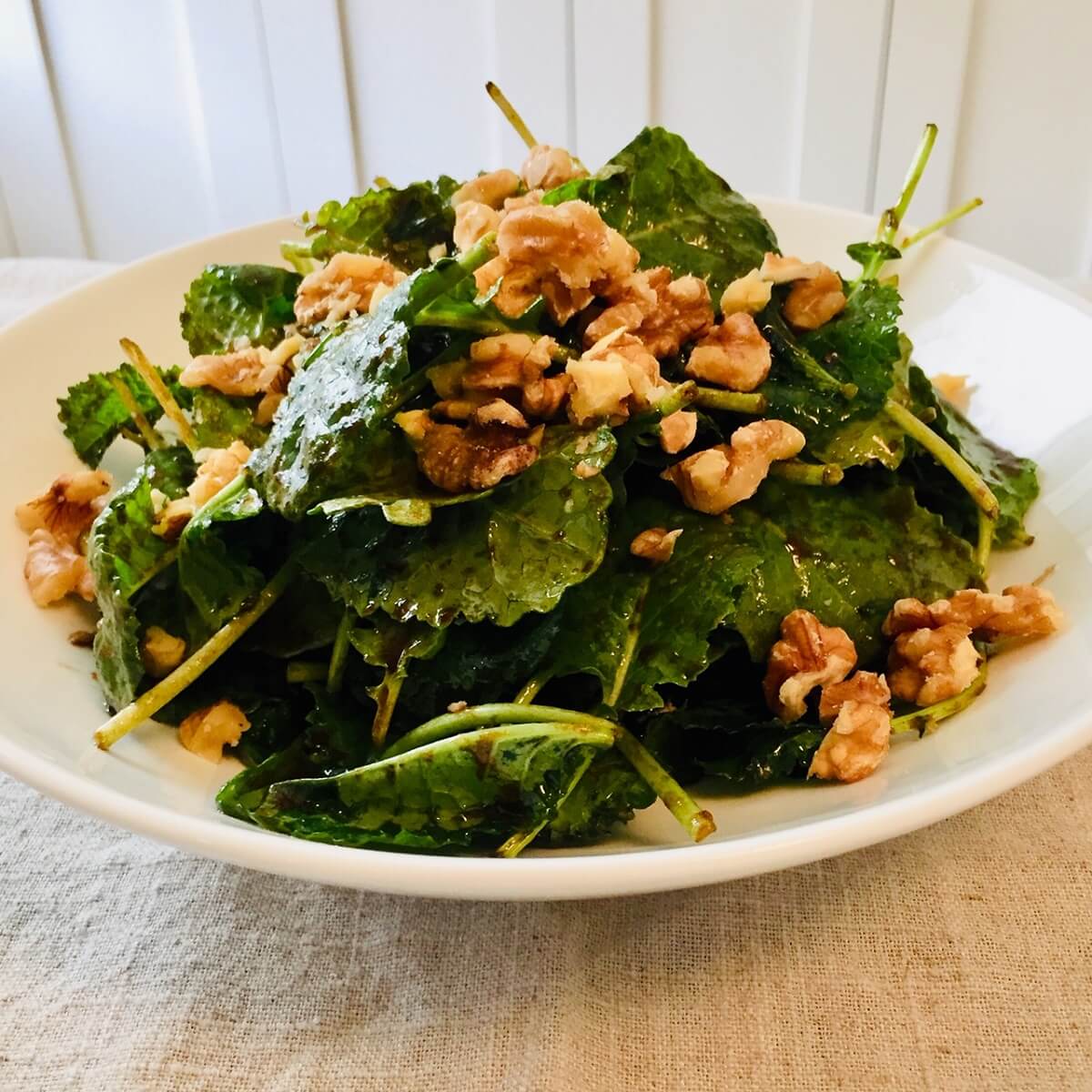 A white bowl filled with kale salad.