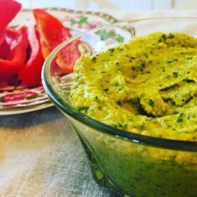 Close up of hummus in a glass bowl.