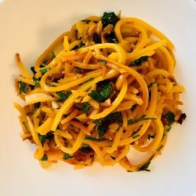 Butternut squash noodles on a white plate.