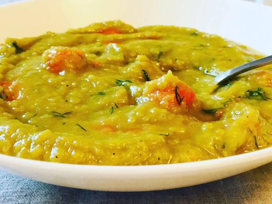 Close up of a bowl of green split pea soup.