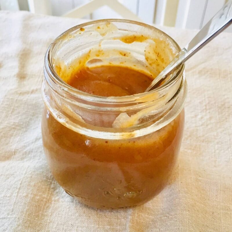 A glass mason jar filled with caramel sauce.