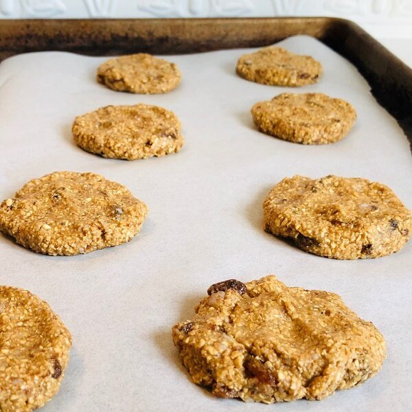 A baking tray of raw oatmeal cookies.