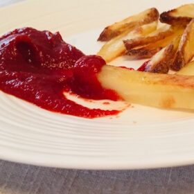 Ketchup and fries on a white plate.