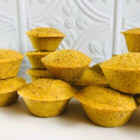 A grouping of mini cornbread muffins on a white counter.