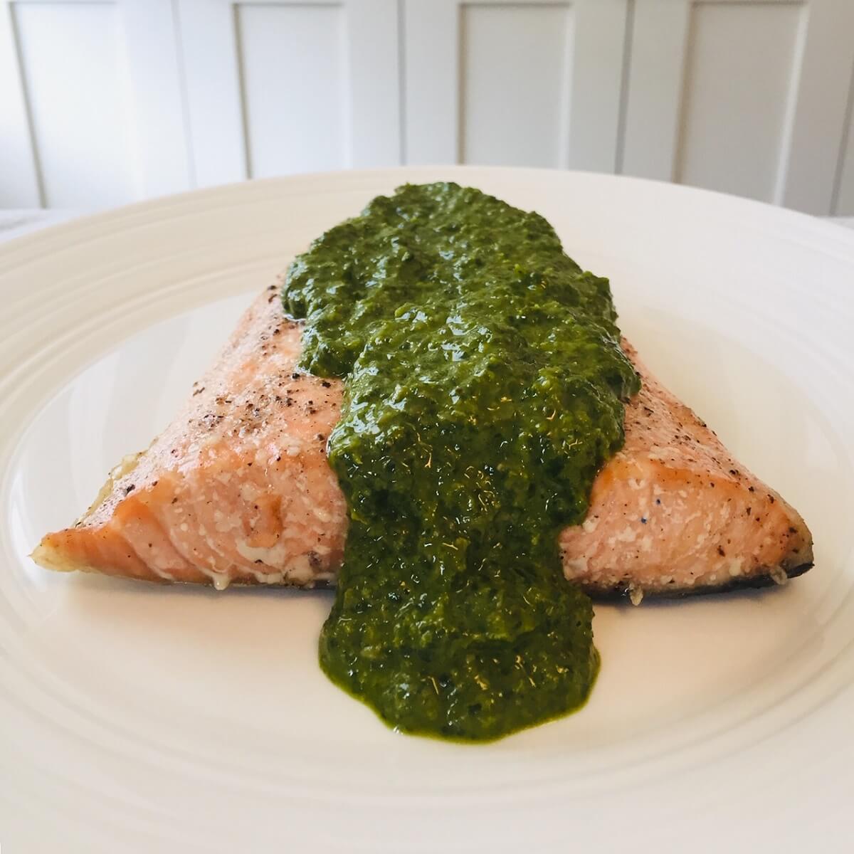 A piece of fish smothered in a green lemon herb sauce.