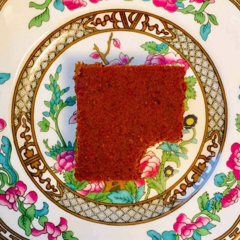A piece of pumpkin cake on a colorful floral plate.