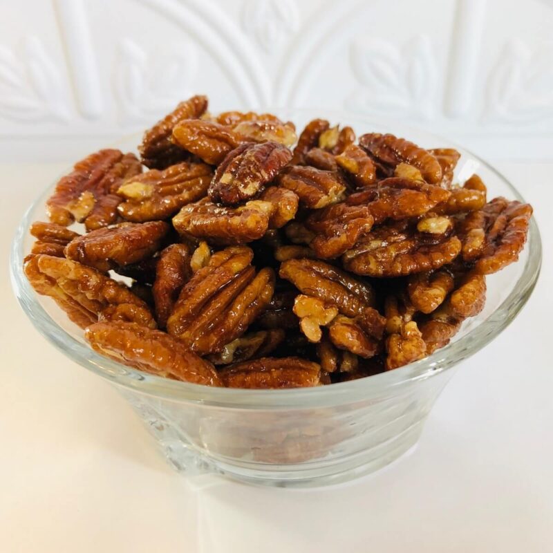 A glass dish filled with pecans.