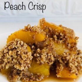 Peach crisp on a plate against a white tile background.