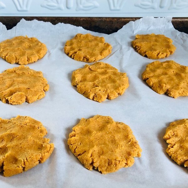 Raw cookies on parchment paper on a sheet pan.