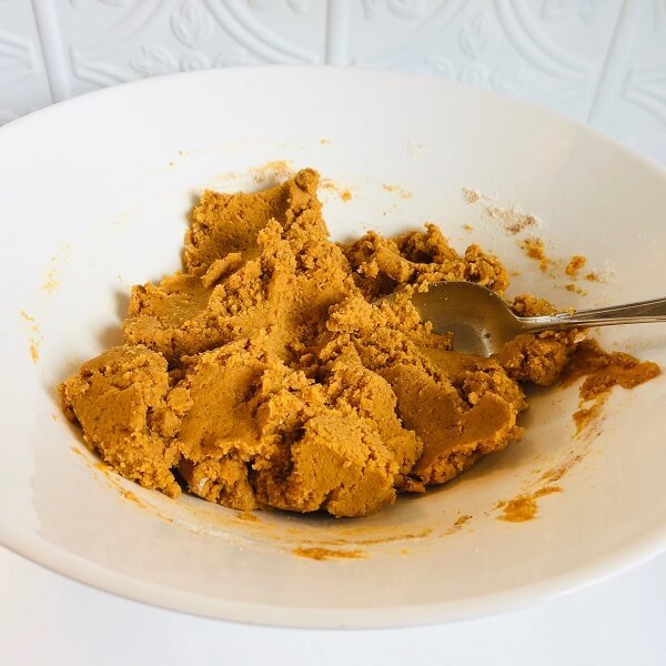 Raw cookie dough in a white mixing bowl.