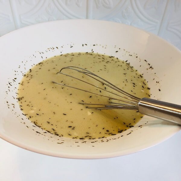 Liquid in a large white bowl with a whisk.
