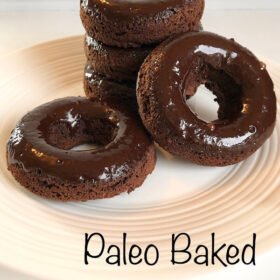 Chocolate glazed donuts displayed on a white plate.