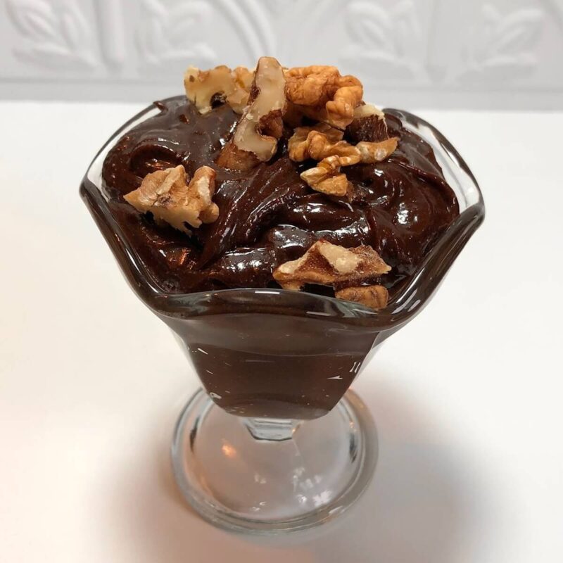 Chopped walnuts sprinkled over a dish of brownie batter.