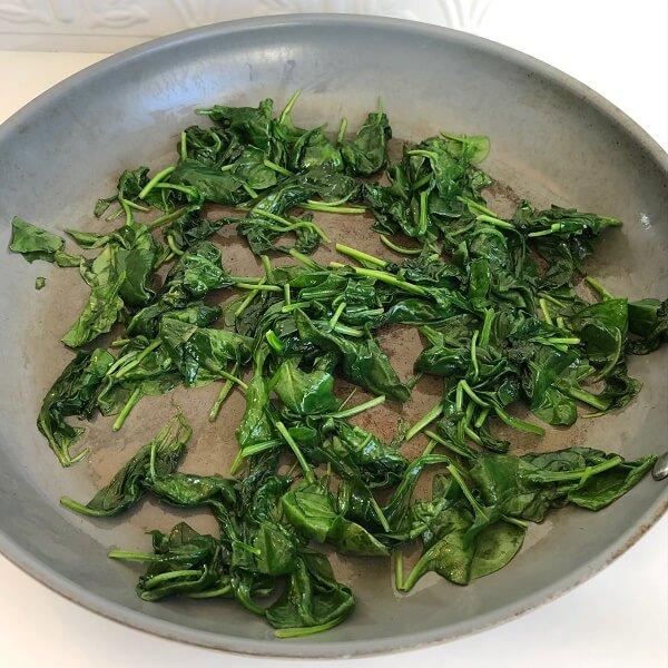 Sauteed spinach in a frying pan.