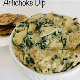 Spinach dip in a dish next to some crackers.