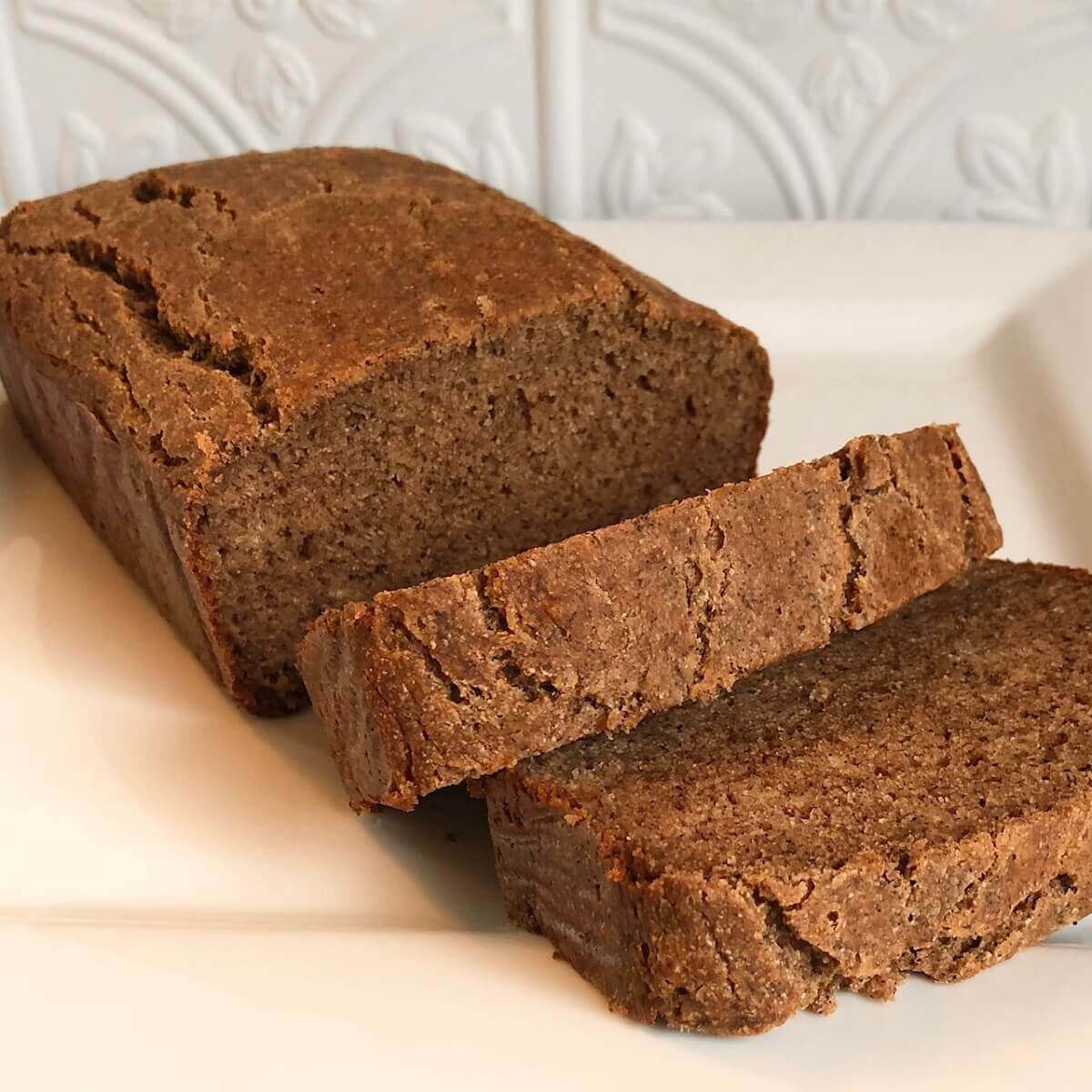 A loaf of vegan buckwheat banana bread on a white platter.