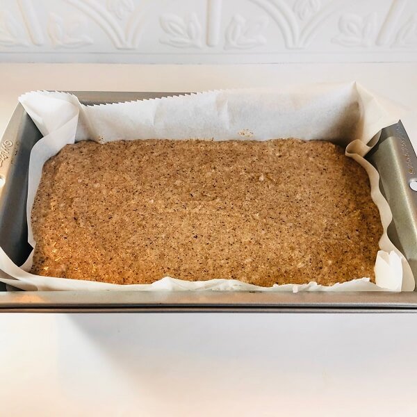 Raw batter in a loaf pan lined with parchment paper.