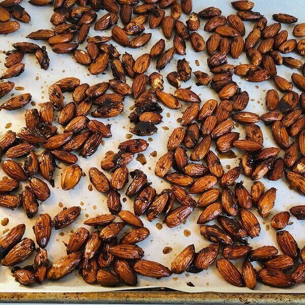 Candied almonds drying on a baking sheet.