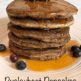 A stack of pancakes topped with blueberries.