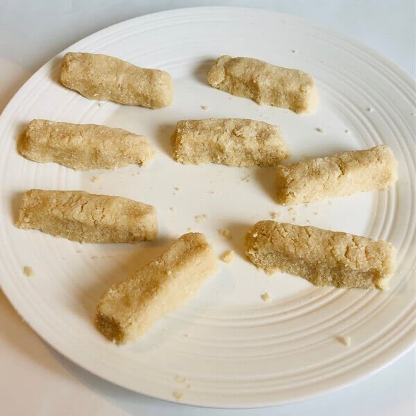 Eight coconut bars on a white plate.