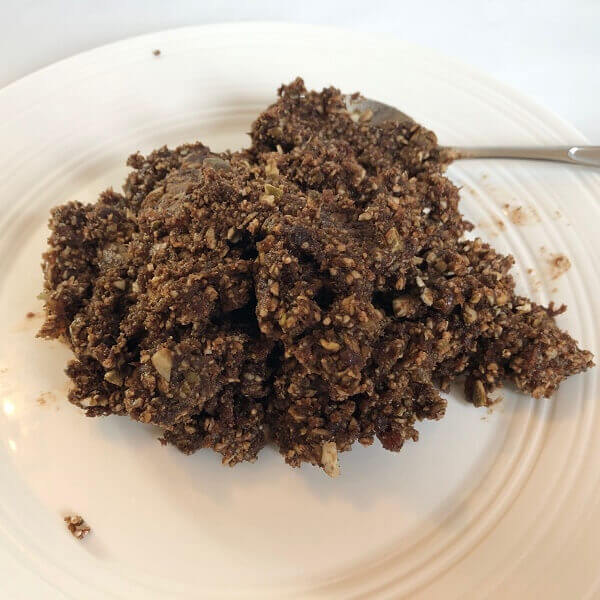 A pile of date dough on a white plate.