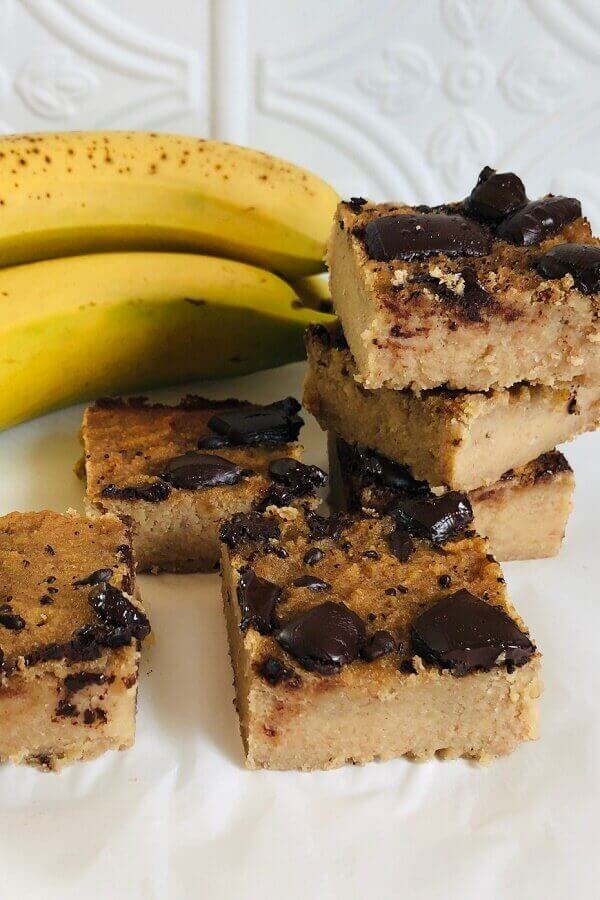 Blondies on a plate next to bananas.