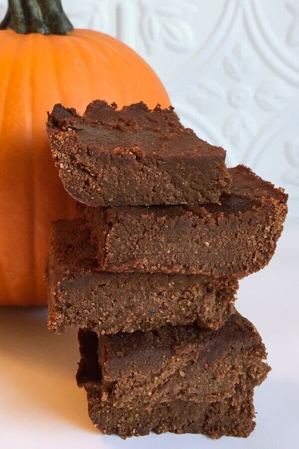 Brownies stacked next to a pumpkin.