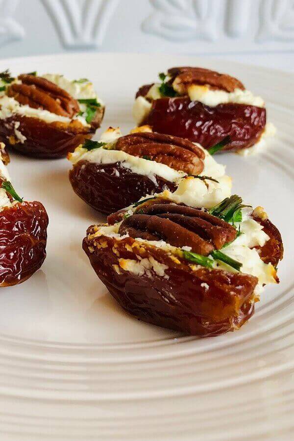 Stuffed dates arranged on a white plate.