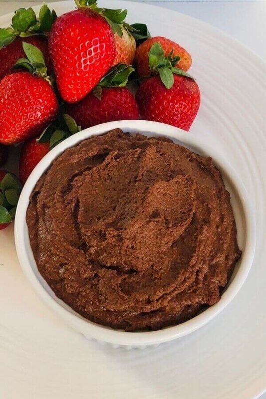 Hummus and strawberries on a plate.