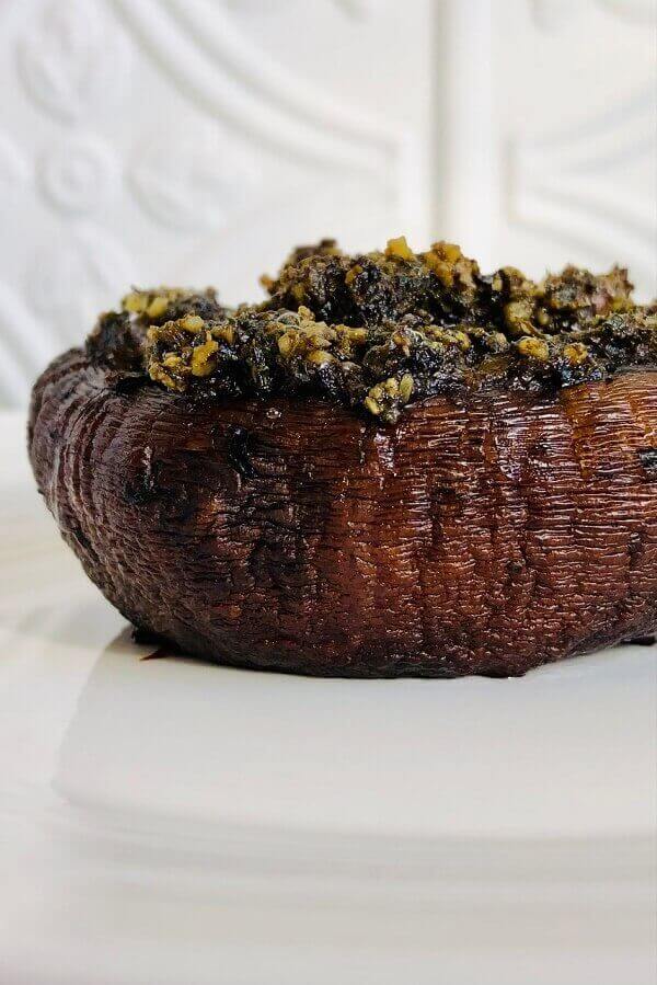 A stuffed mushroom on a white plate.