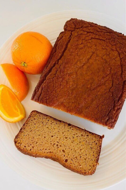 Cake next to oranges on a plate.