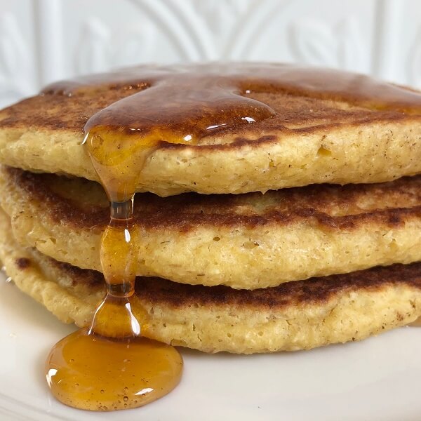 Pancakes stacked with syrup dripping down.
