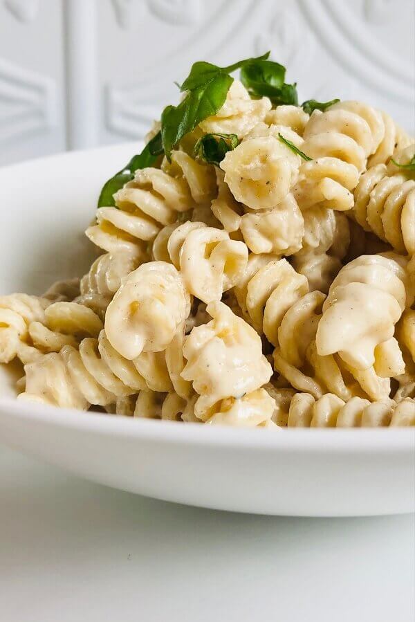 Pasta with tahini sauce in a white bowl.