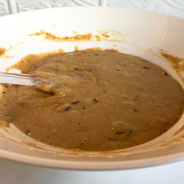 Banana bread batter in a large white bowl.