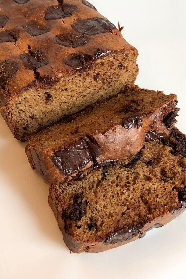 Banana bread loaf next to two slices.