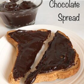 Toast slathered in chocolate spread on a white plate.