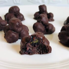 Chocolate blackberries on a white plate.