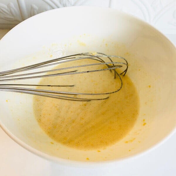 Cracker batter in a bowl with a whisk.