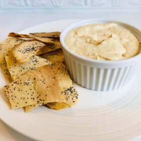 Crackers and dip on a white plate.