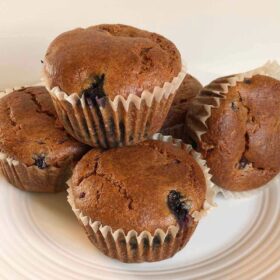 Five chickpea flour muffins displayed on a plate.