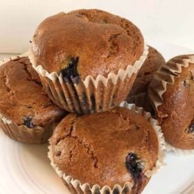 Muffins stacked and arranged on a plate.