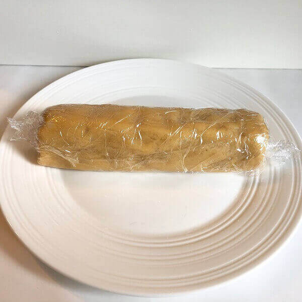 A log of cookie dough wrapped in plastic wrap.