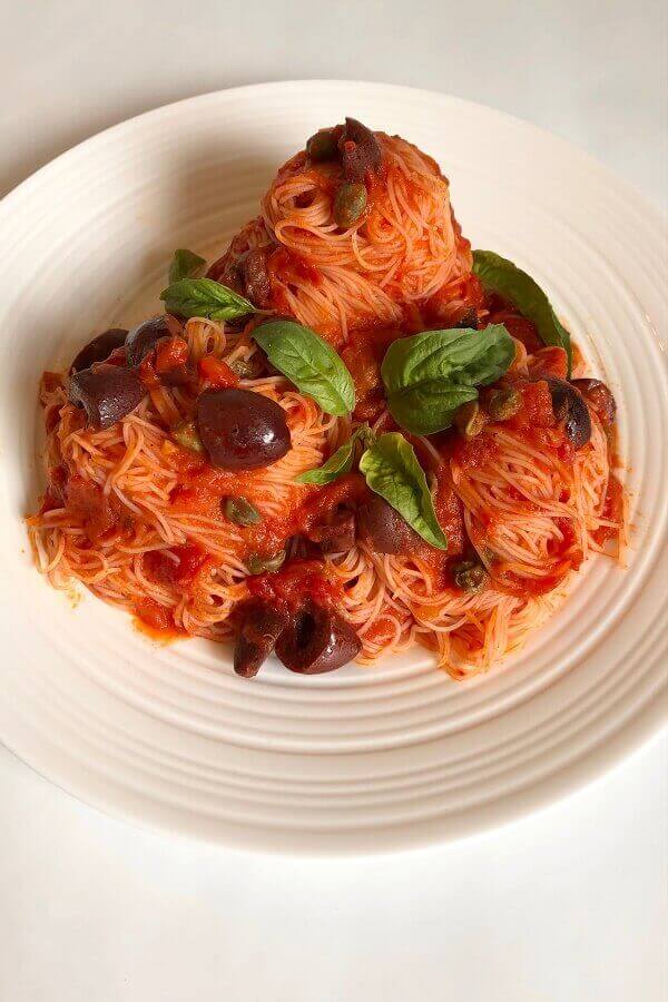 Pasta with olives and capers on a plate.