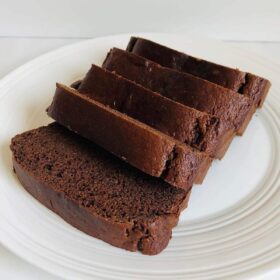 Five slices of chickpea flour cake on a white plate.