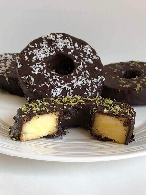 Chocolate dipped pineapple on a plate.