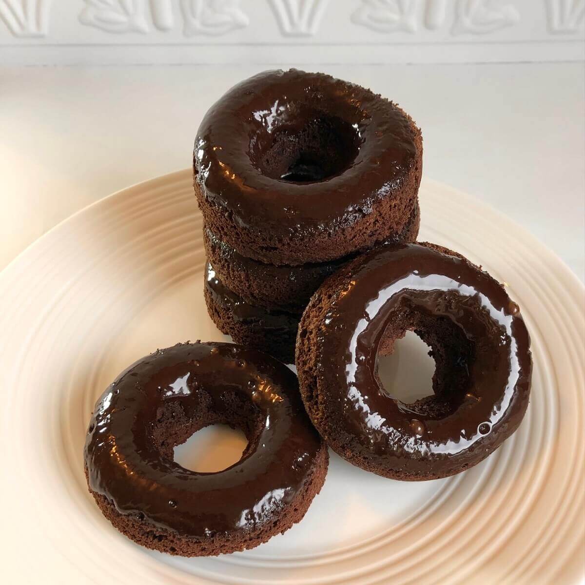 Donuts stacked on a plate.