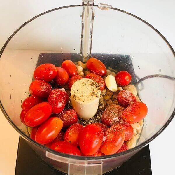 Tomatoes, cashews, and garlic in a food processor.