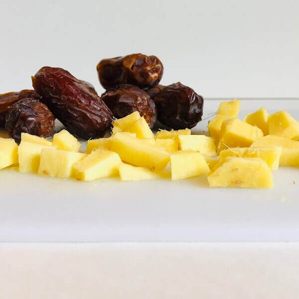 Dates and chopped ginger on a cutting board.